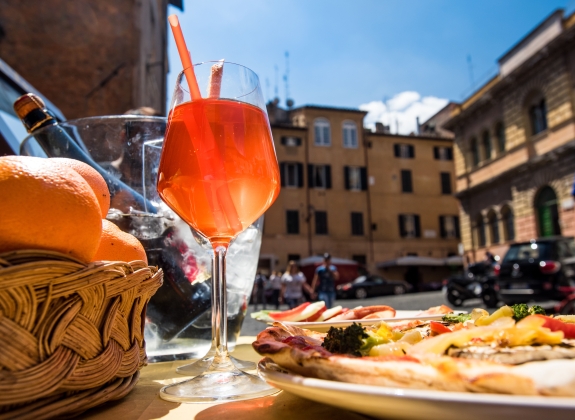 Aperol spritz cocktail and Italian pizza on a piazza Santa Maria in Trastevere. Rome,Italy