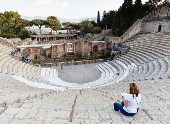 Woman reading a book in the amphitheater of Pompeii, Neapel, Italy, europa