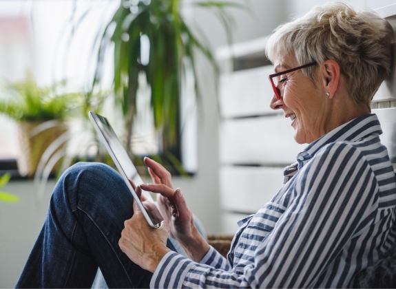 Senior woman using digital tablet at home.