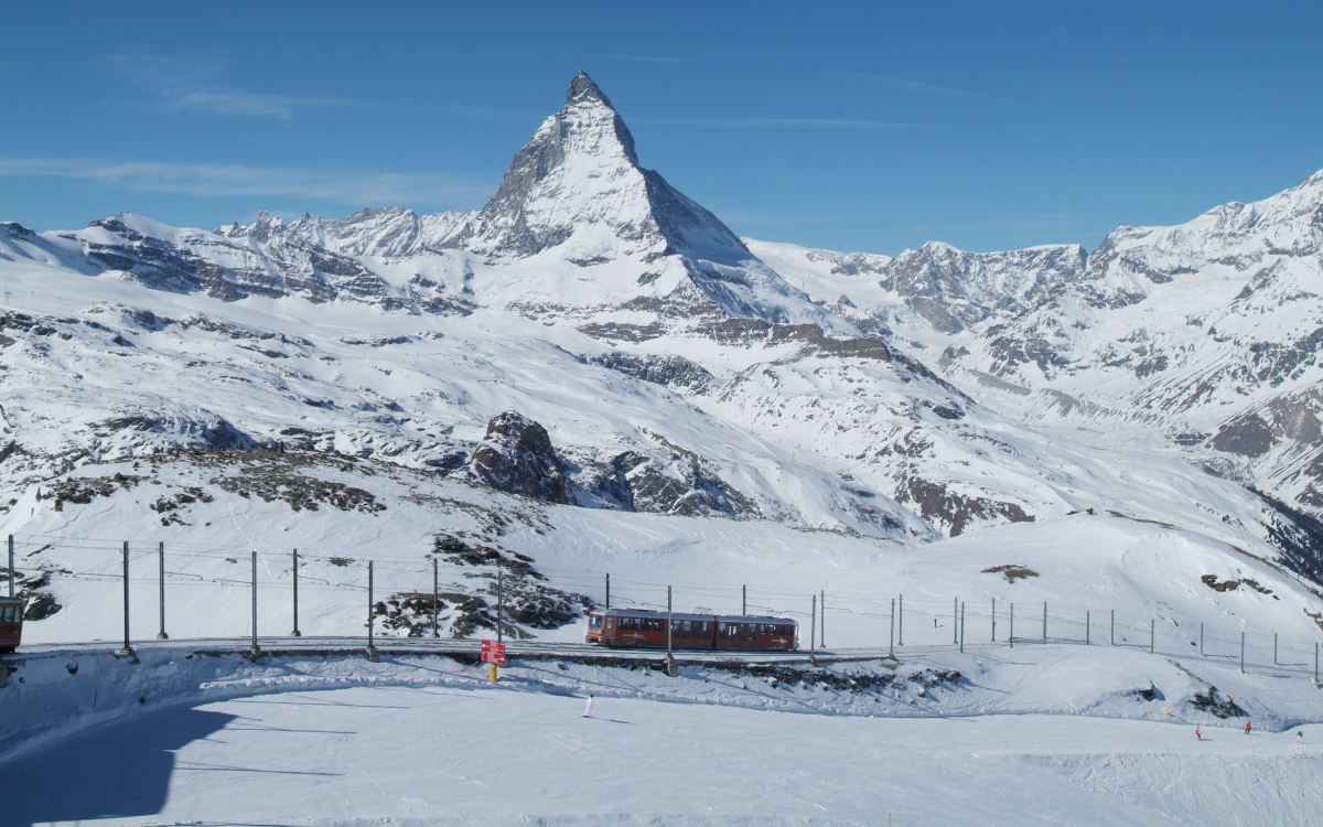 Travelling on the Gornergrat A train travels through snowy mountains