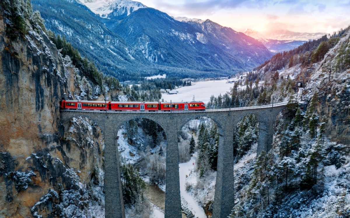 Aerial view of Train passing through famous mountain in Filisur, Switzerland train express in Swiss Alps snow winter scenery.