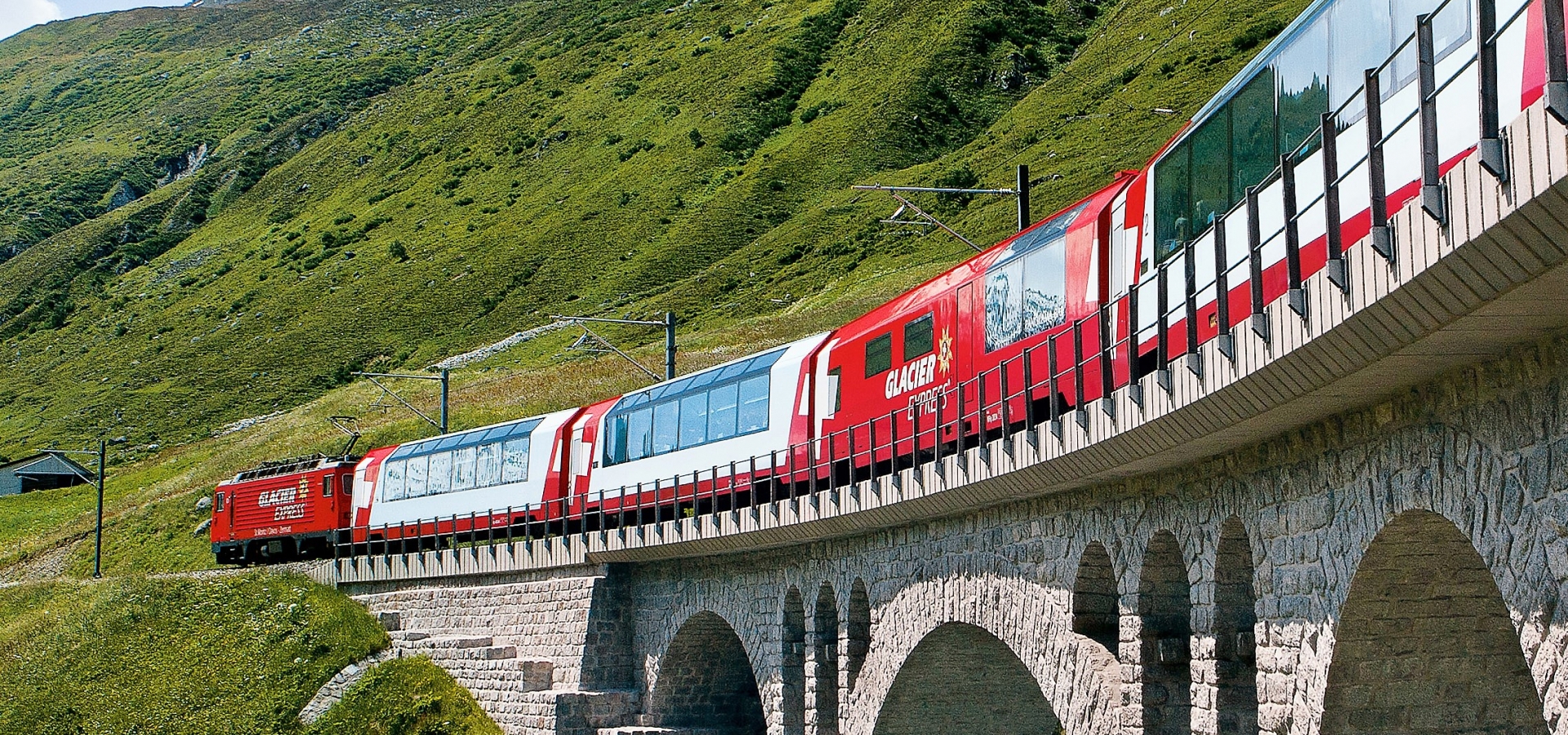Travelling on the Glacier Express A train travels over a small river in Switzerland