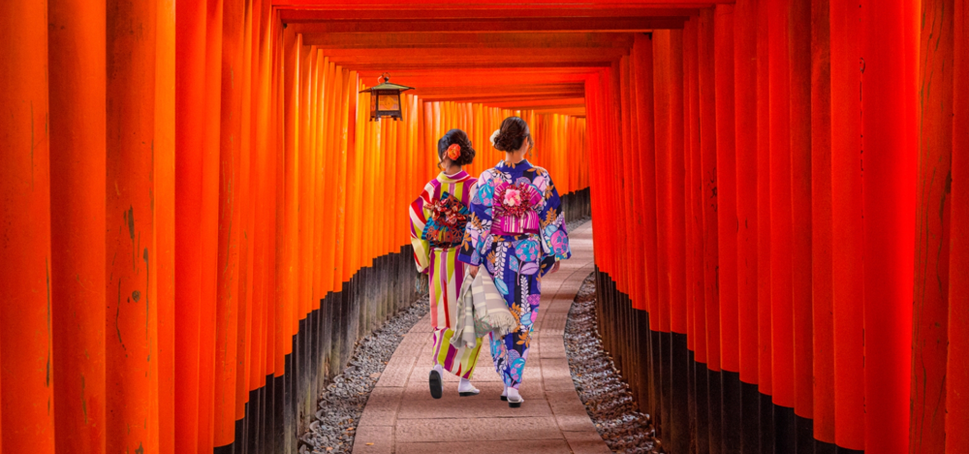 Women in traditional japanese kimonos walking at Fushimi Inari Shrine in Kyoto, Japan