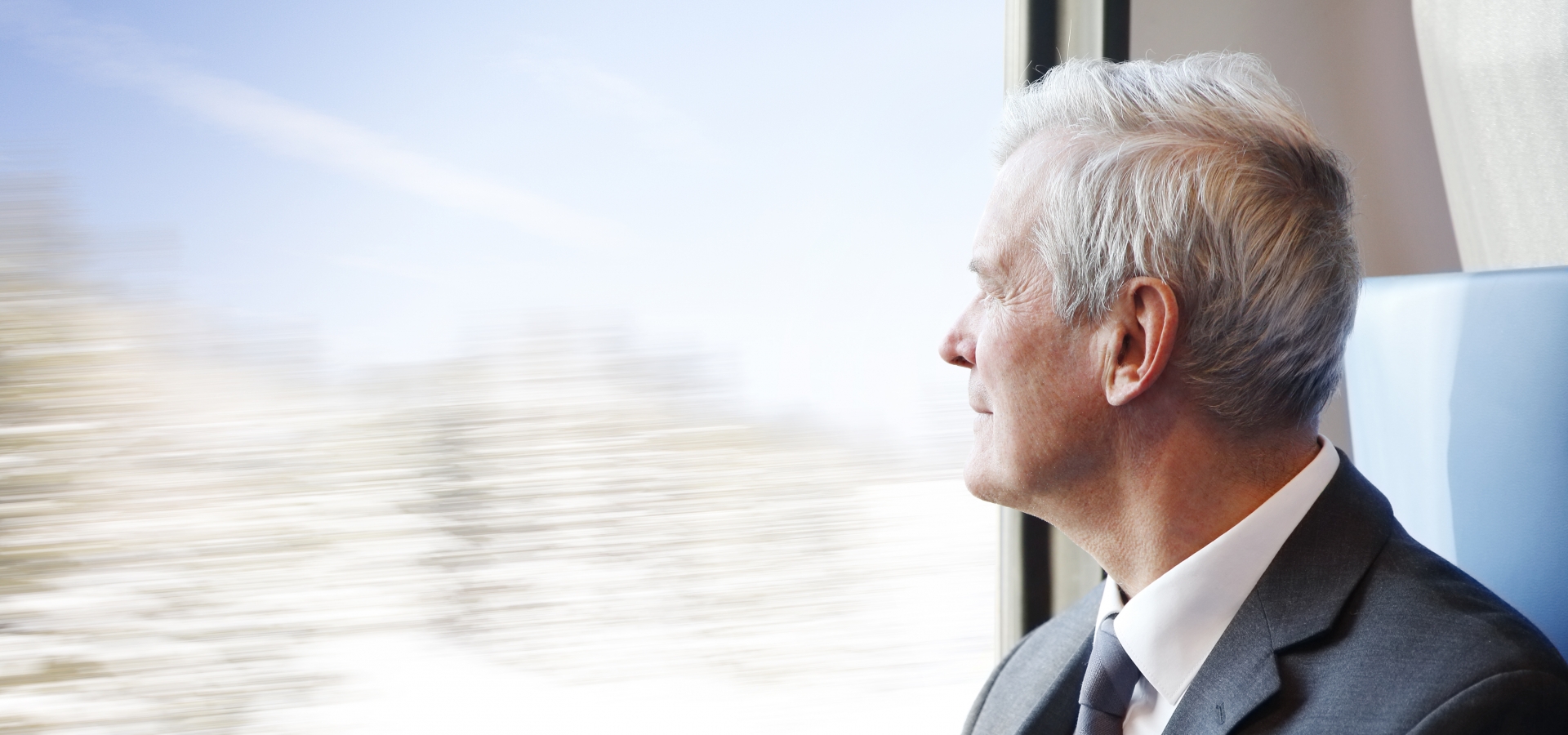 Portrait of commuter man traveling by train and looking through window the winter landscape