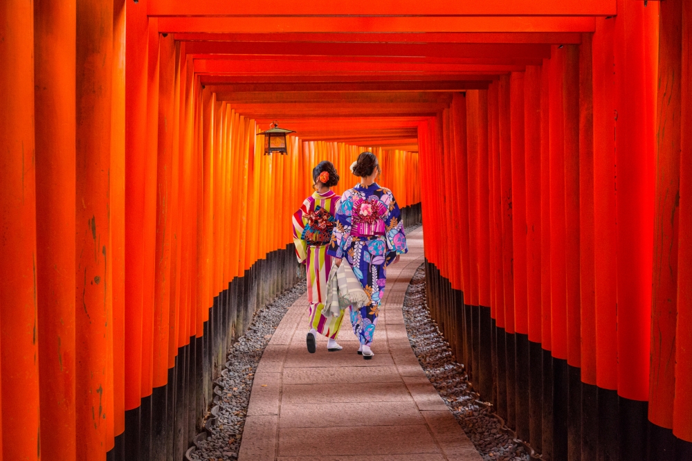 Women in traditional japanese kimonos walking at Fushimi Inari Shrine in Kyoto, Japan