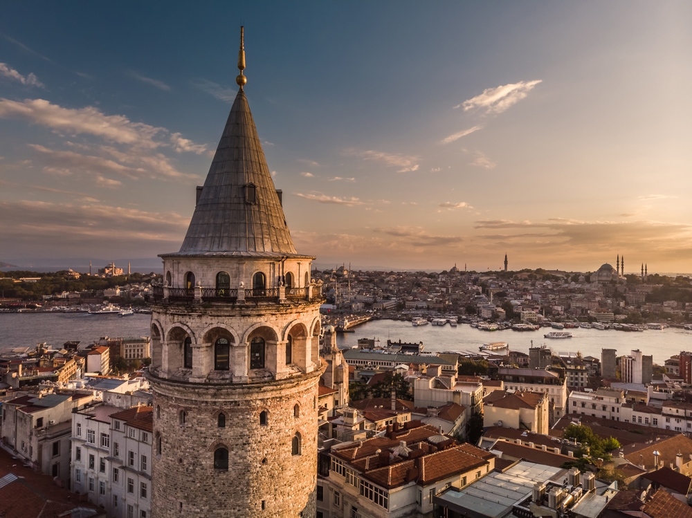 Aerial evening shot of the Galata Tower in Istanbul, Turkey. Aerial view of landmark at golden hour with beautiful sunlight.