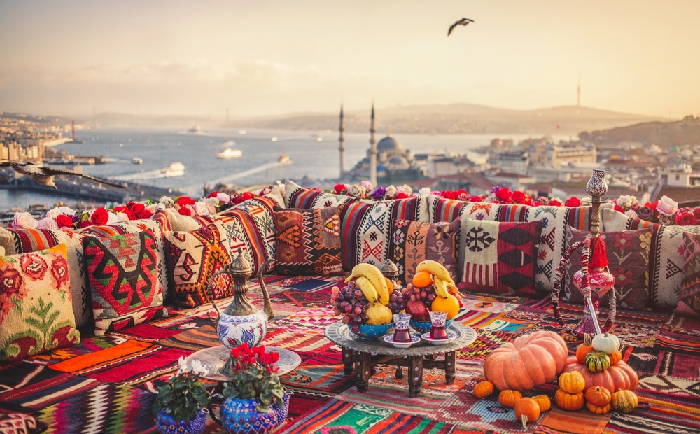 Great panoramic view of Istanbul from high terrace decorated traditional colorful ornamental pillows and carpets. Selective focus