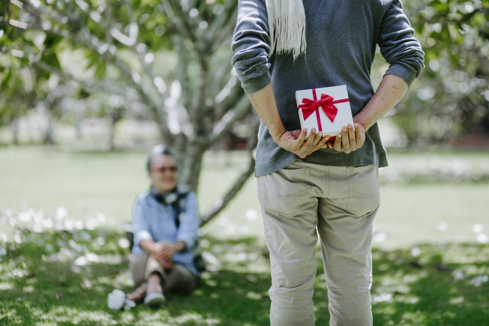 man holding present behind his back for a special occasion